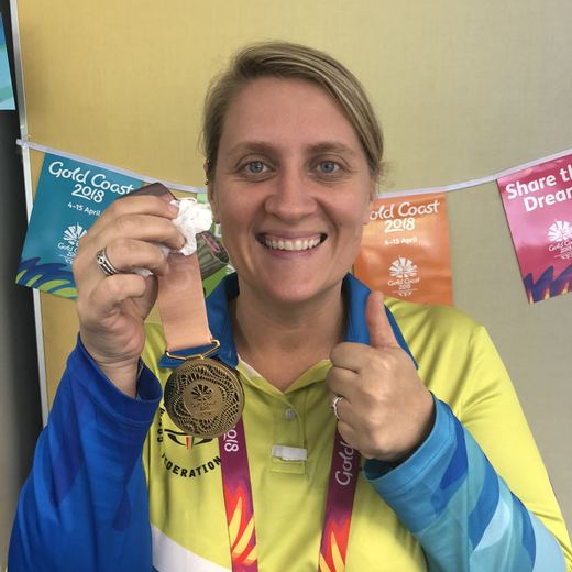 Holding a GC2018 medal in volunteer uniform